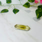 citrine double point crystal on white marble with leaves and flowers