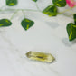 citrine double point crystal on white marble with leaves and flowers