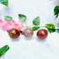 colorful ocean jasper spheres on marble in front of vines and flowers