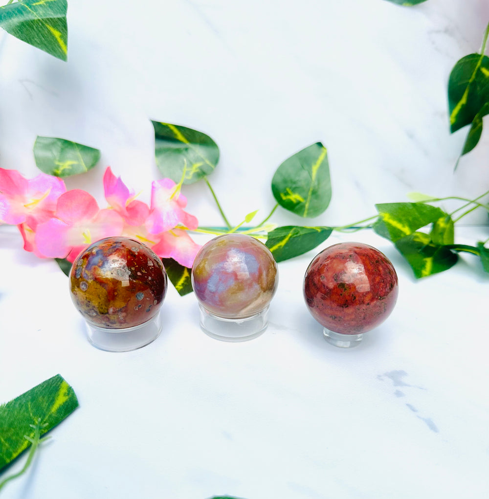 colorful ocean jasper spheres on marble in front of vines and flowers