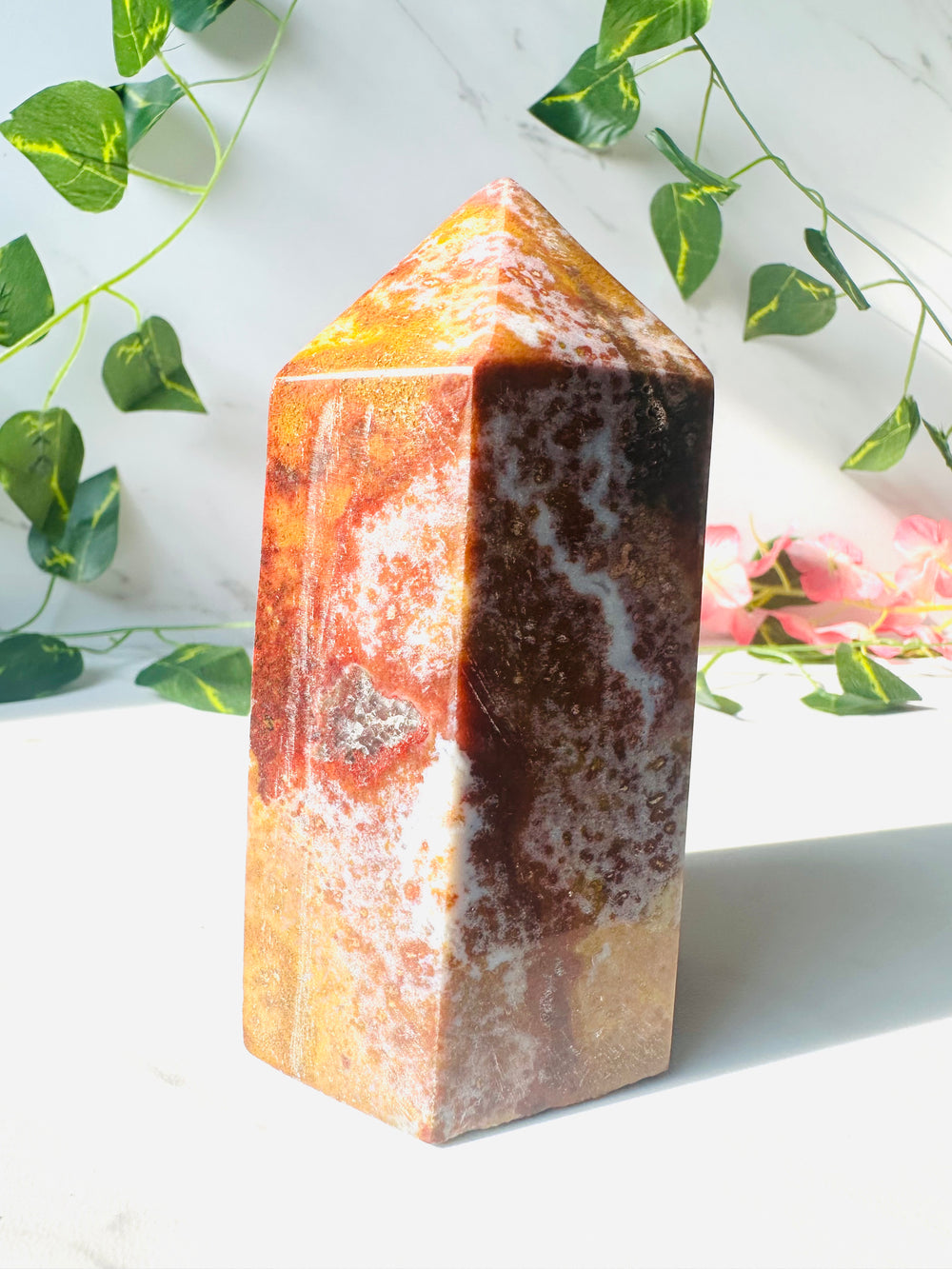 large ocean jasper tower standing on marble in front of vines