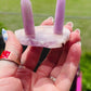 two kunzite towers sit on a pink amethyst base. handcrafted crystal ring holder fits ring sizes 2.5 and bigger. 