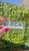 woman hand holding a white and black sticker that says W.I.T.C.H woman in total control of herself 