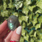 3 beautiful labradorite palm stones are showcased in a womans hand showing off colorful flashes of blue, green, orange, yellow and more.