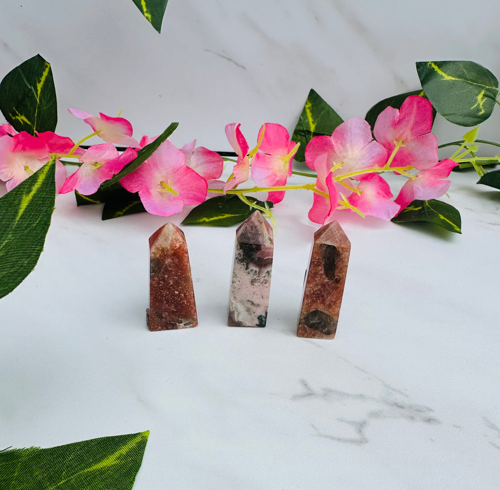 arusha golden sun towers and rhodochrosite towers mini sitting on marble surrounded by vines and flowers