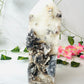 Zebra Jasper with Sphalerite Druzy Tower XL on marble in front of vines and flowers